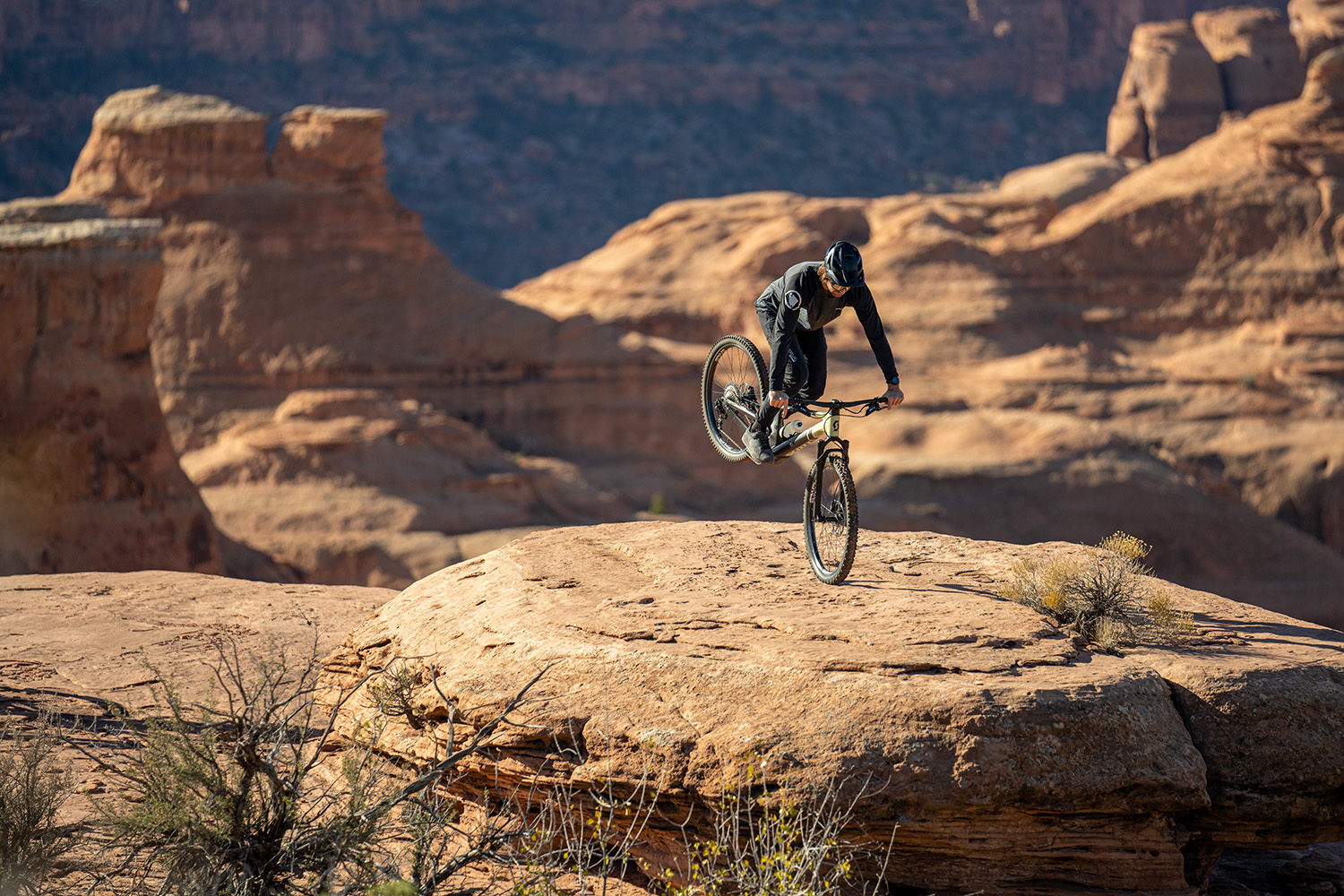 Eric doing an endo on a rock on the edge of a cliff.