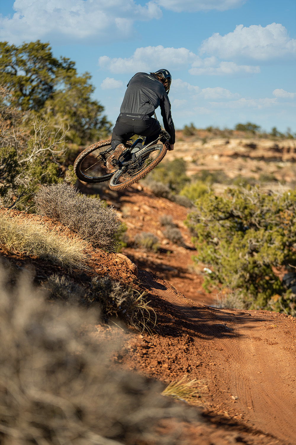 Eric riding away from the camera jumping in the air tweaking his bike sideways.