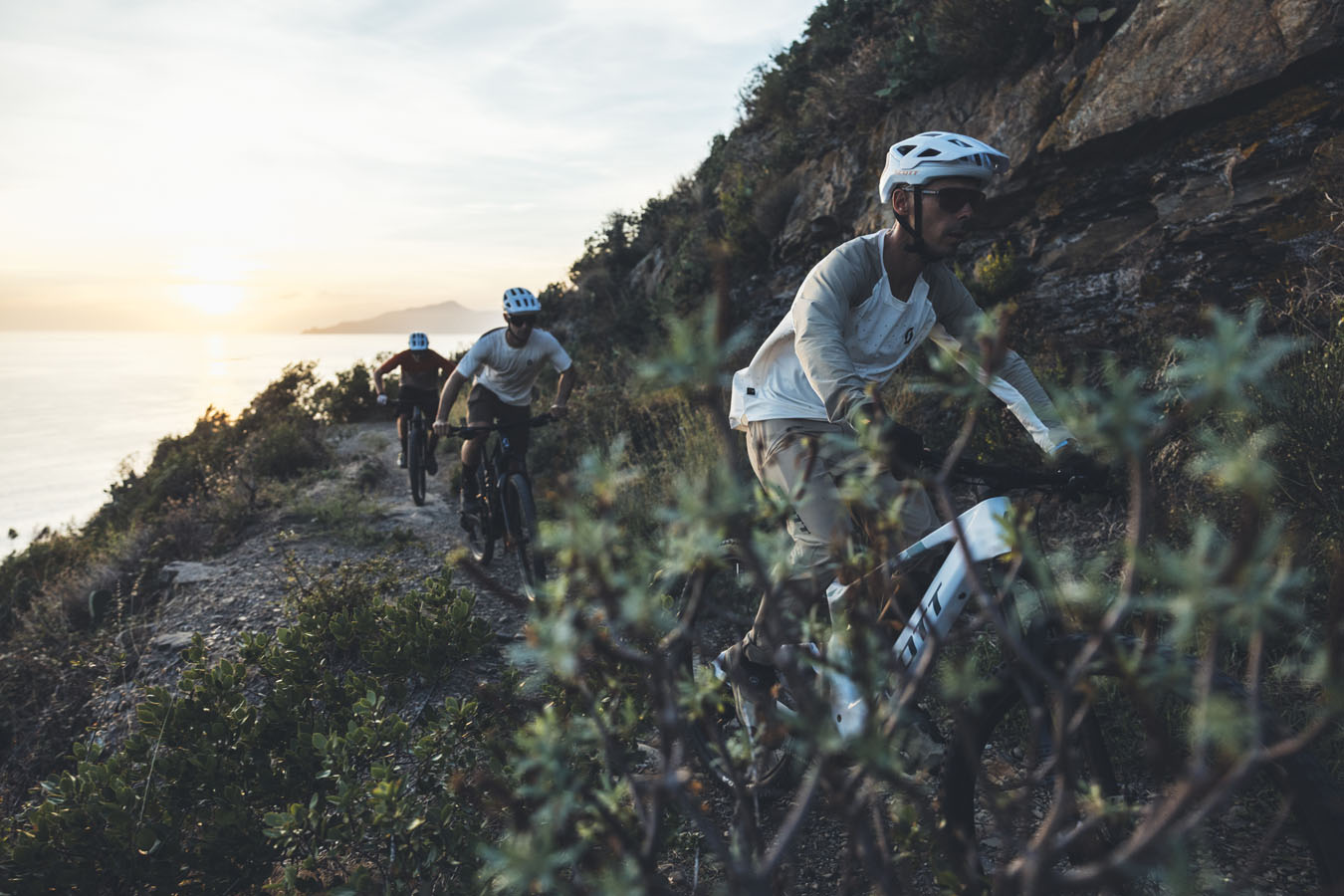 Three mountain bikers riding on the coast
