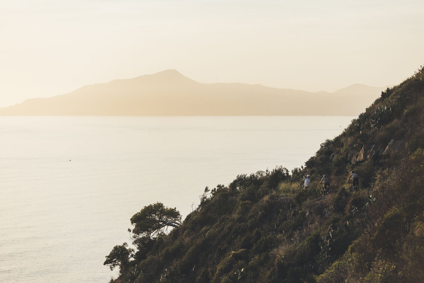 Three mountain bikers riding on the coast