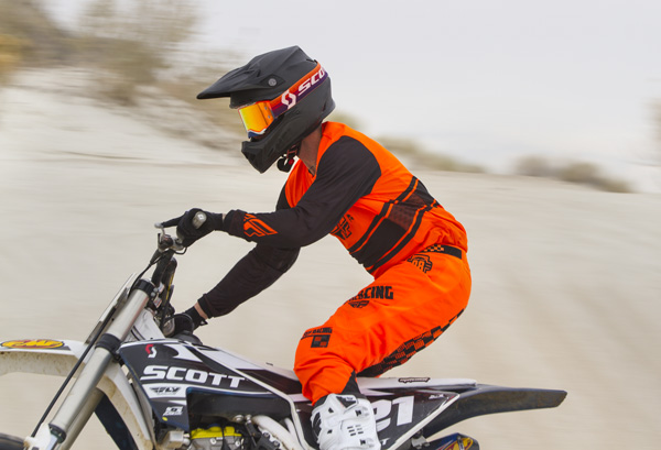 Scott rider wearing an orange kit wearing the mojve prospect goggle riding sideways