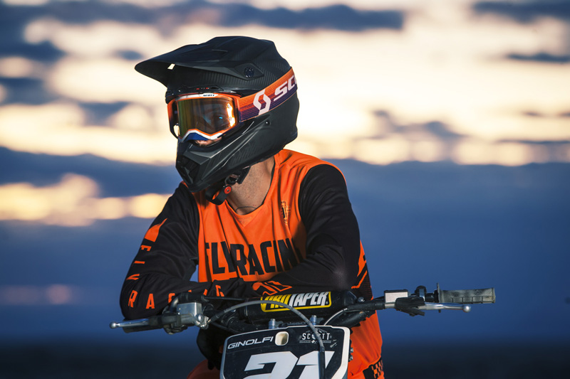 Scott rider on motorcycle wearing an orange kit with the Mojve Prospect goggle with the sunset behing him