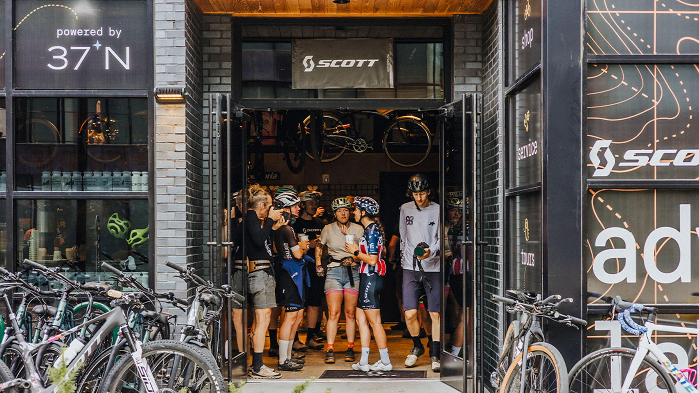 A group of cyclists stand in the doorway of SCOTT Adventure Lab in Bentonville, Arkansas.