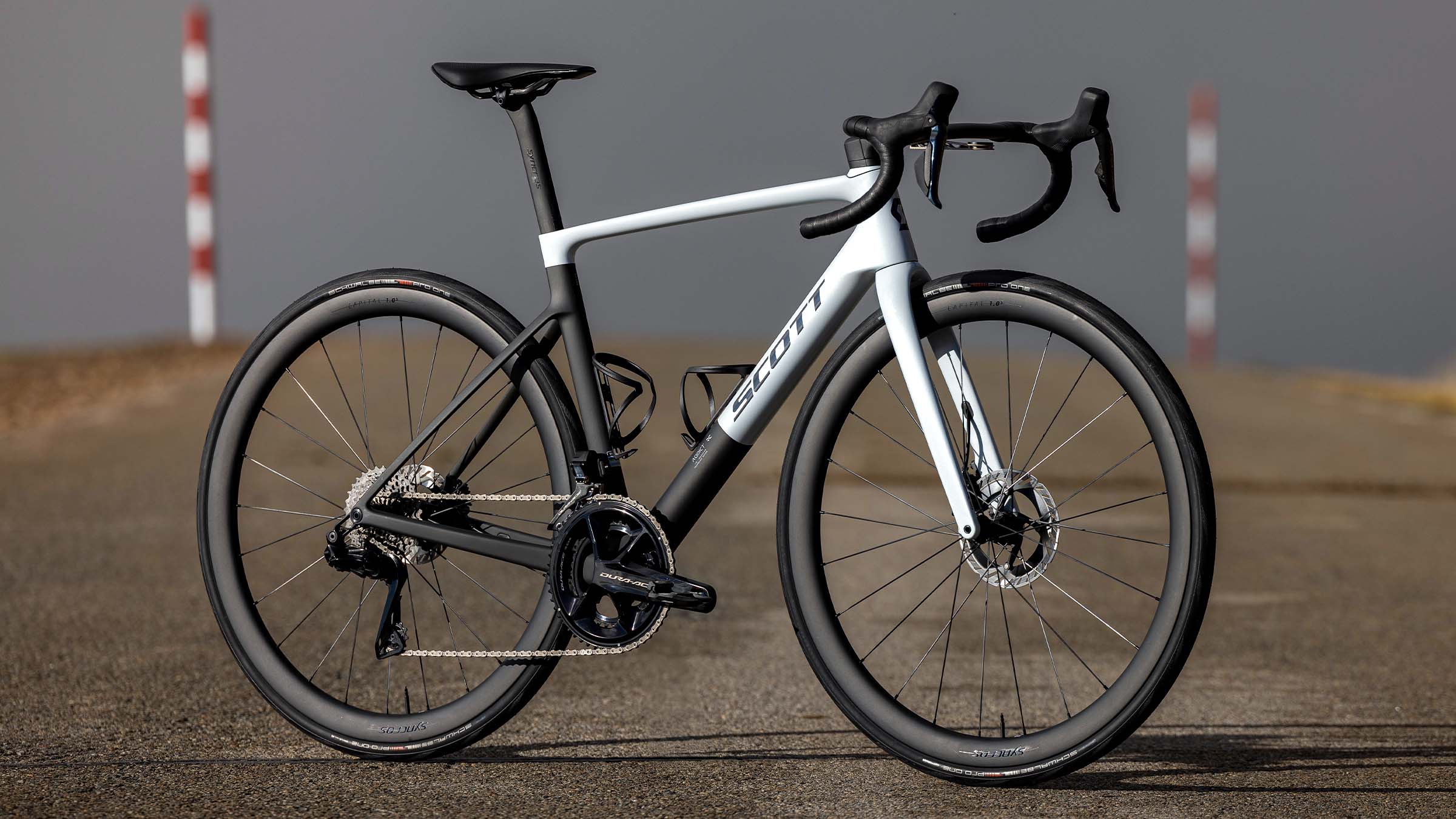 SCOTT Addict RC Pro factory build road bike in black and white, shown drive-side on an open road