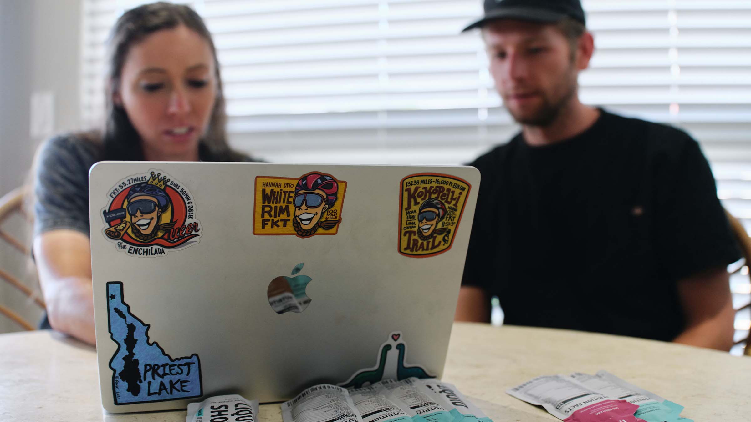 Hannah Otto sitting next to her partner, Clayton Otto, reviewing the Manua Kea FKT route on her laptop.