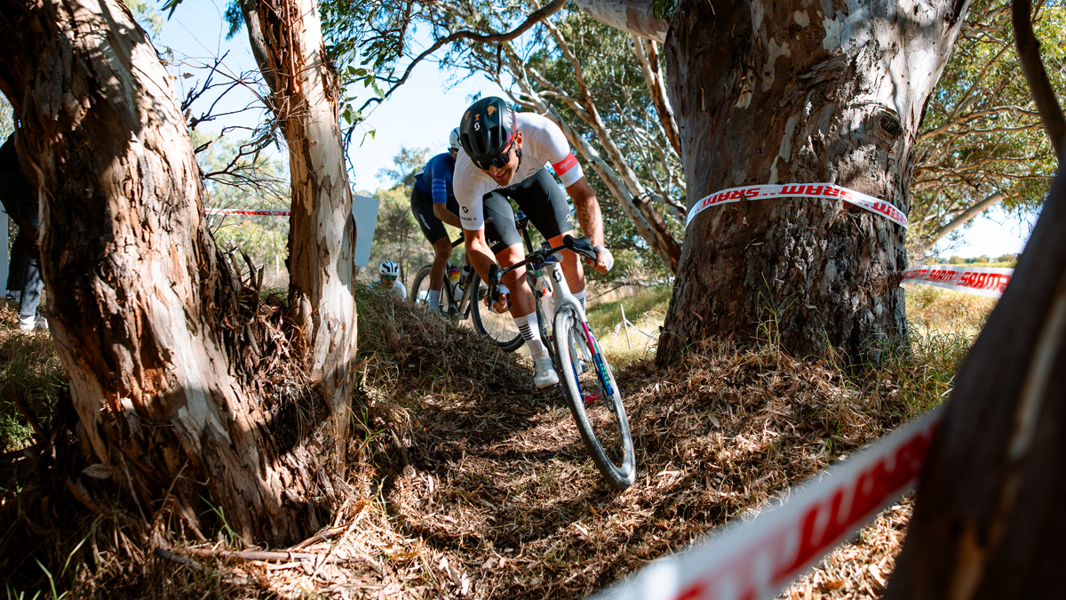 Cameron Jones Gravel Biking between trees in SCOTT outfit gears