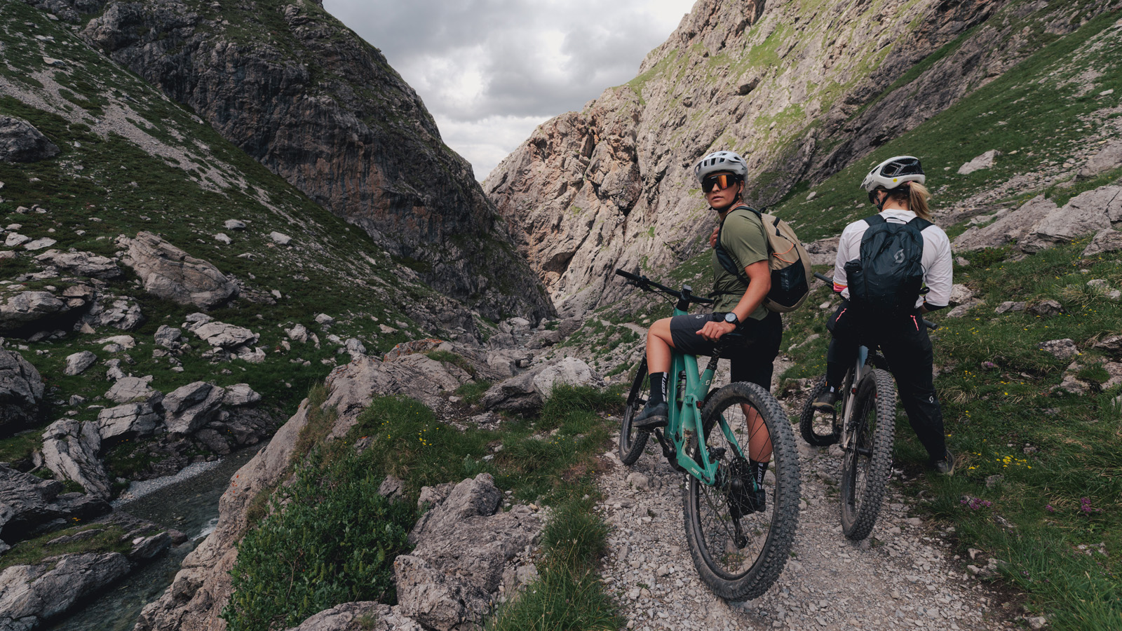 Two women side by side sitting on sCOTT Bikes one is looking behind her