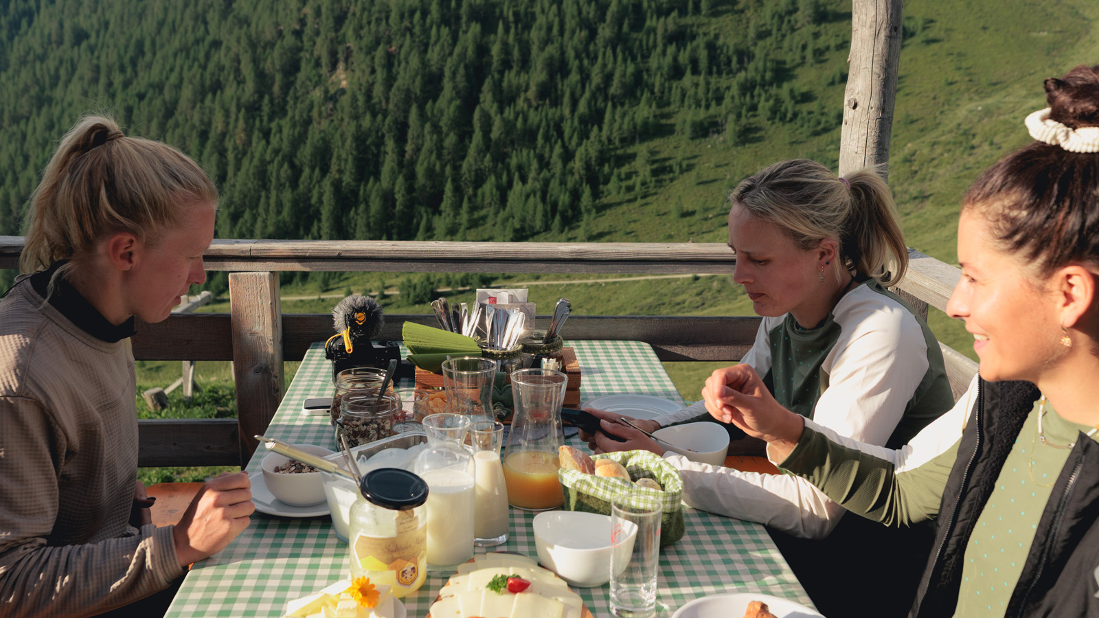 Three women taking their breakfast in the mountains
