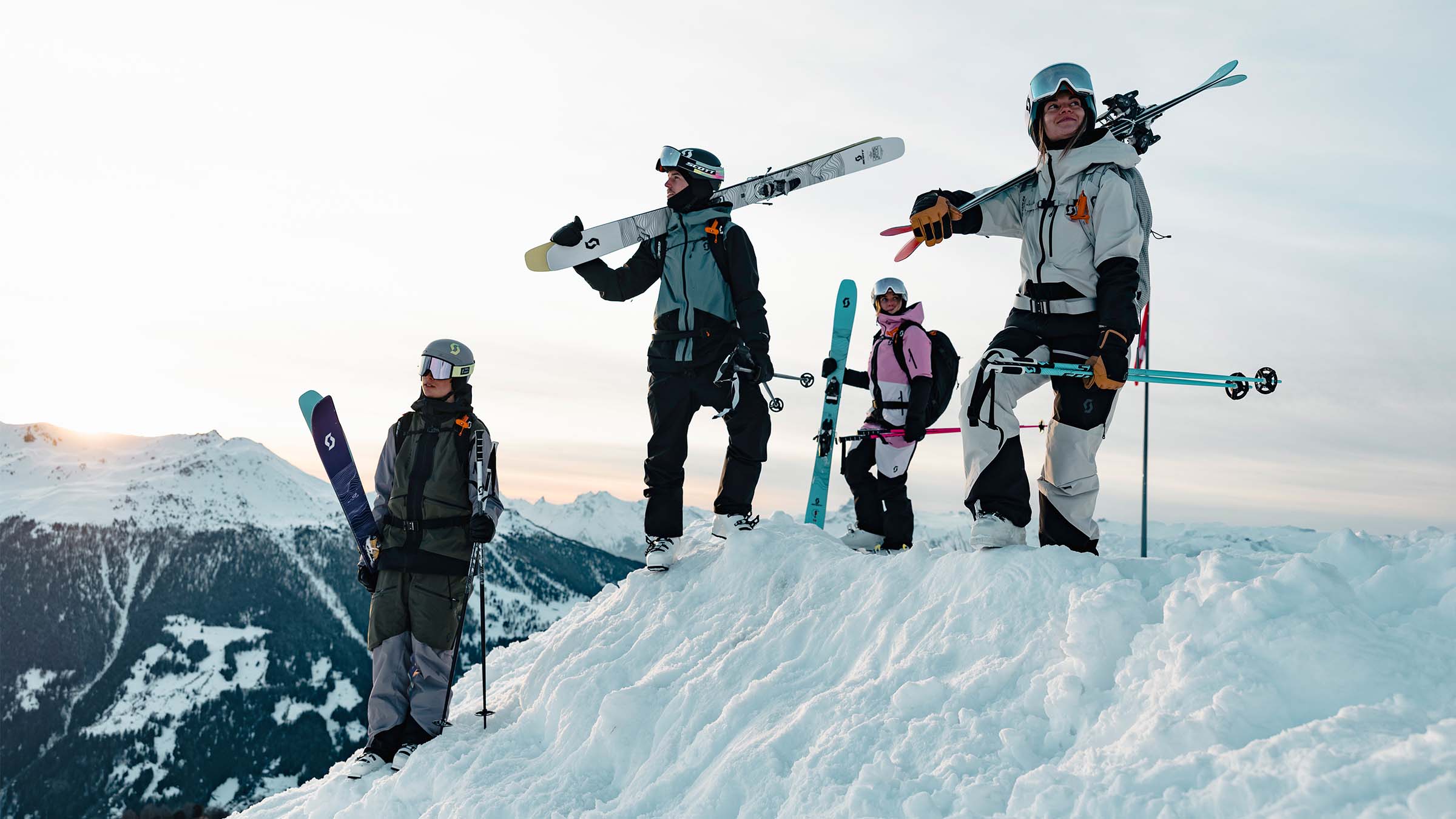 SCOTT How to Choose a Ski Helmet - four skiers at the top of a mountain holding their skis