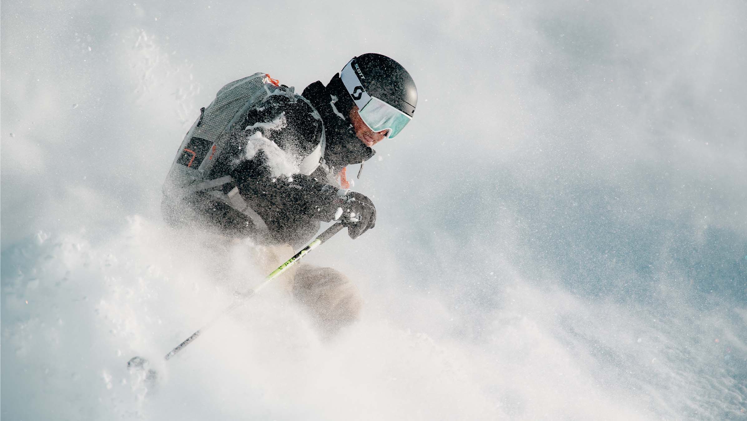 SCOTT How to Choose a Ski Helmet - skier in a cloud of powder snow