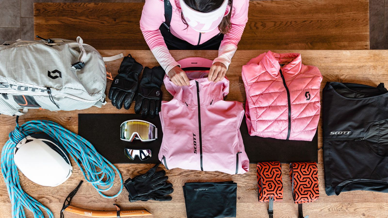 Sabine Schipflinger, SCOTT Winter ambassador, folding a SCOTT fleece on a table surrounded by winter SCOTT apparel items 